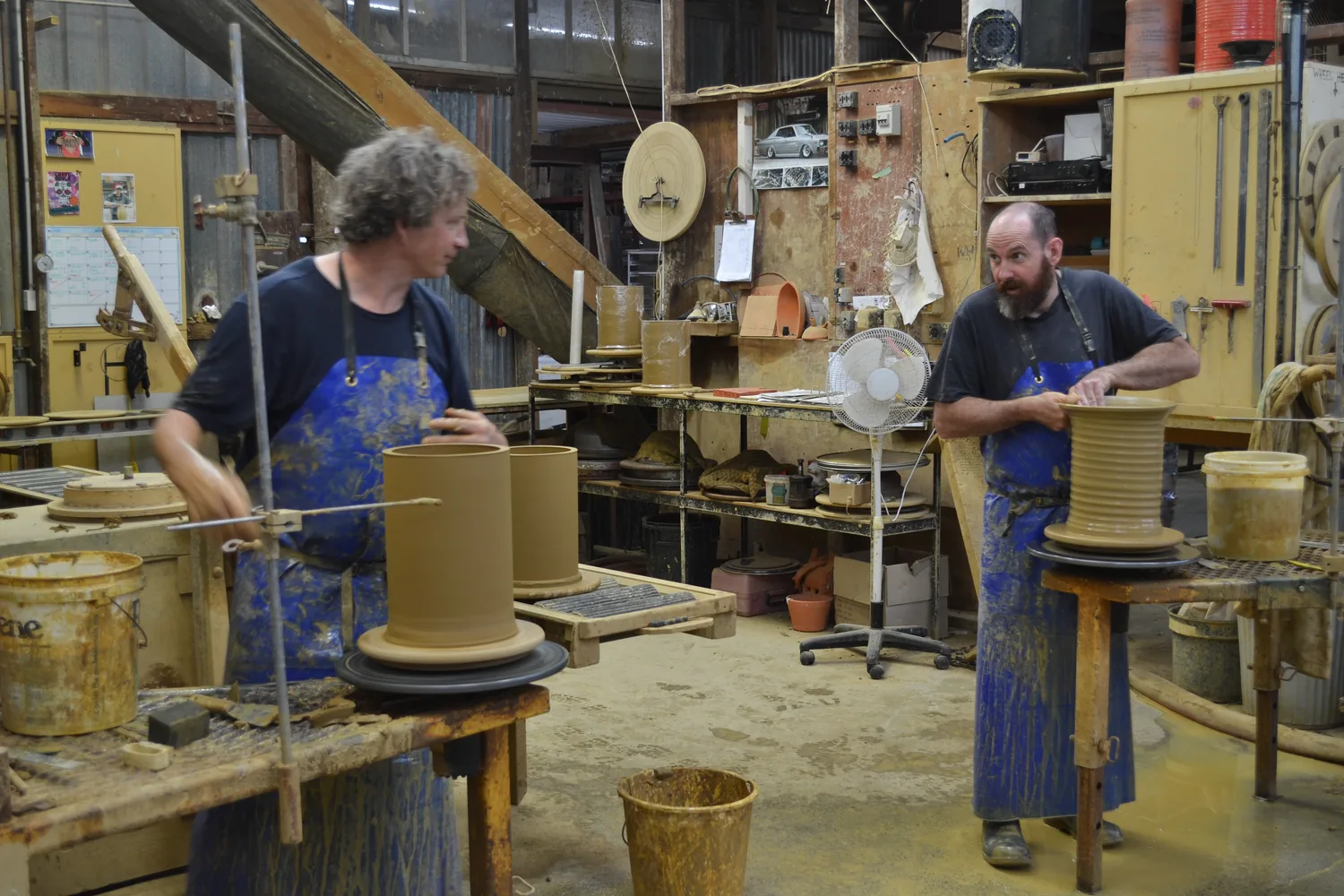 Potters throwing pots at the wheel