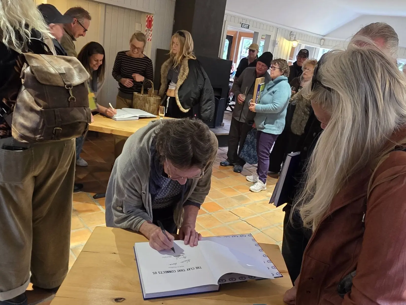 A book being signed as the crowd looks on